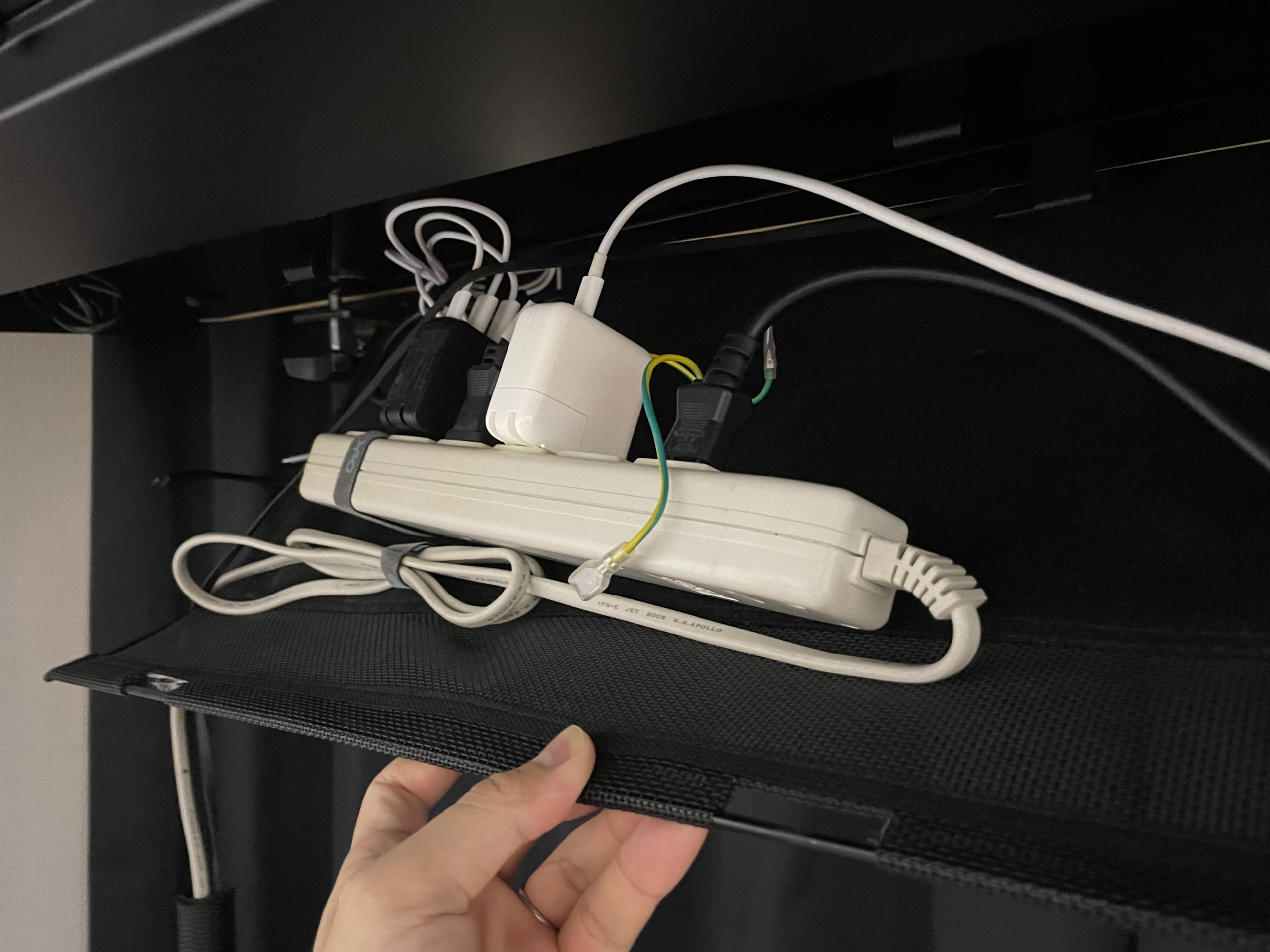 COFO M.CABLE TRAYをデスク天板裏へ磁着し、電源タップを収納している筆者所有実機の様子